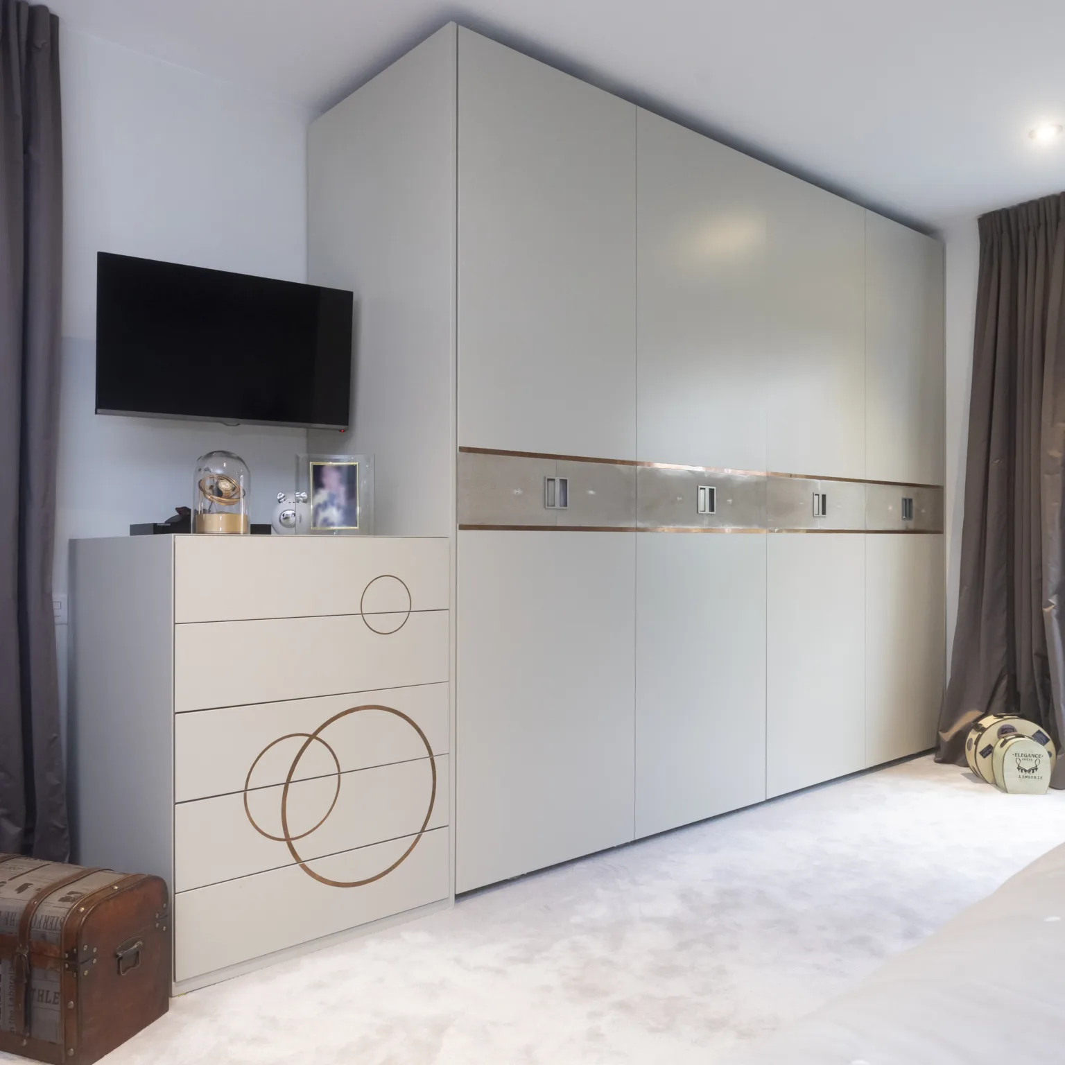 Ensemble de meubles sur mesure en laque claire avec décoration géométrique cuivre"